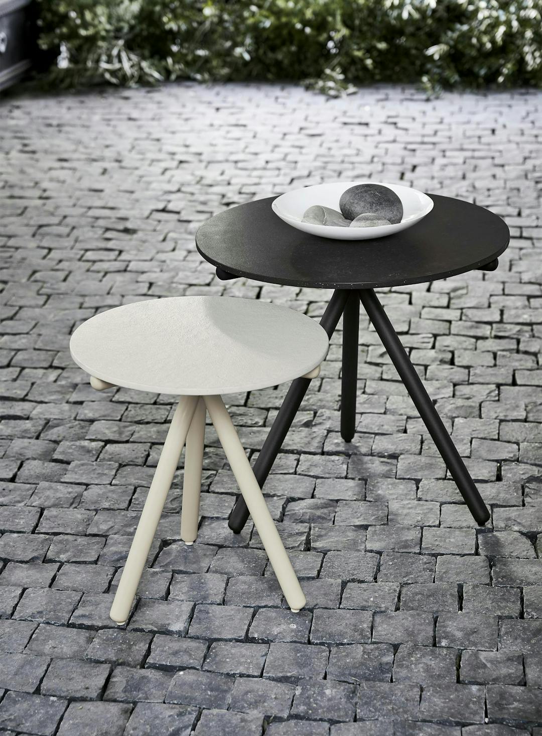 One tall side table in black finish and a shorter side table in white finish. Oscar was designed by Ann Marie Vering.