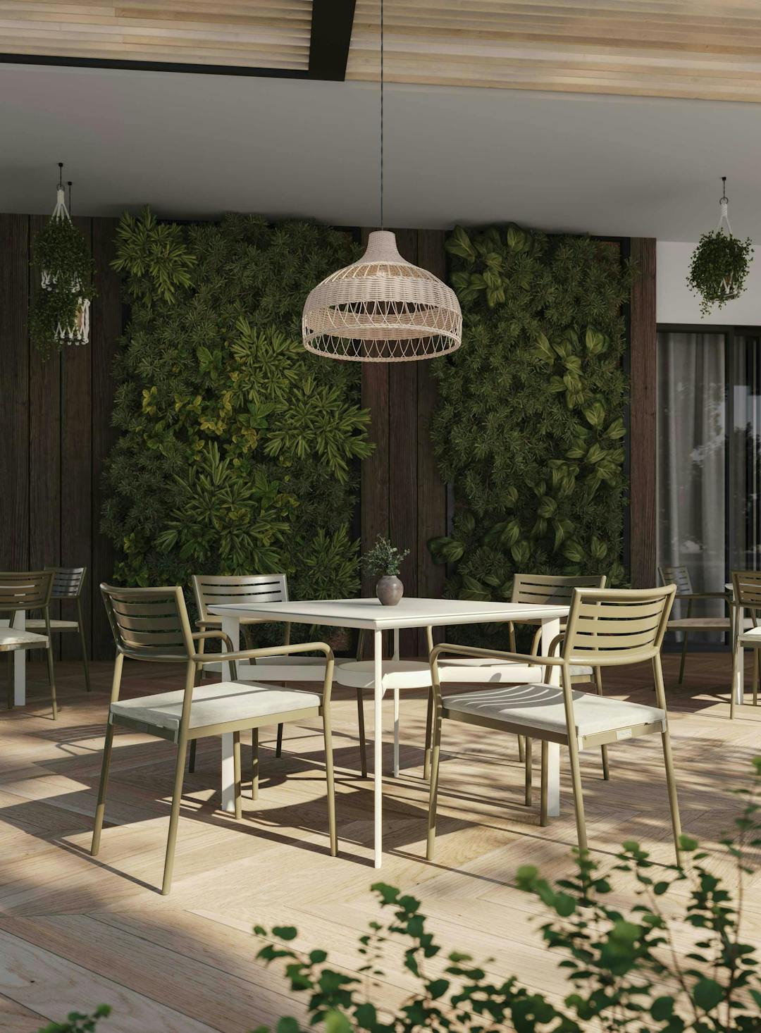 Lisbon collection featuring a dining table and 4 dining chairs around within a restaurant's outdoor area with a plant wall.